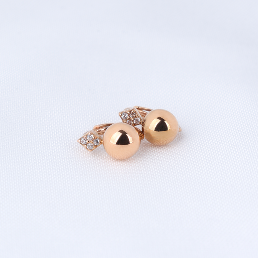 Pair of gold earrings on a light fabric background
