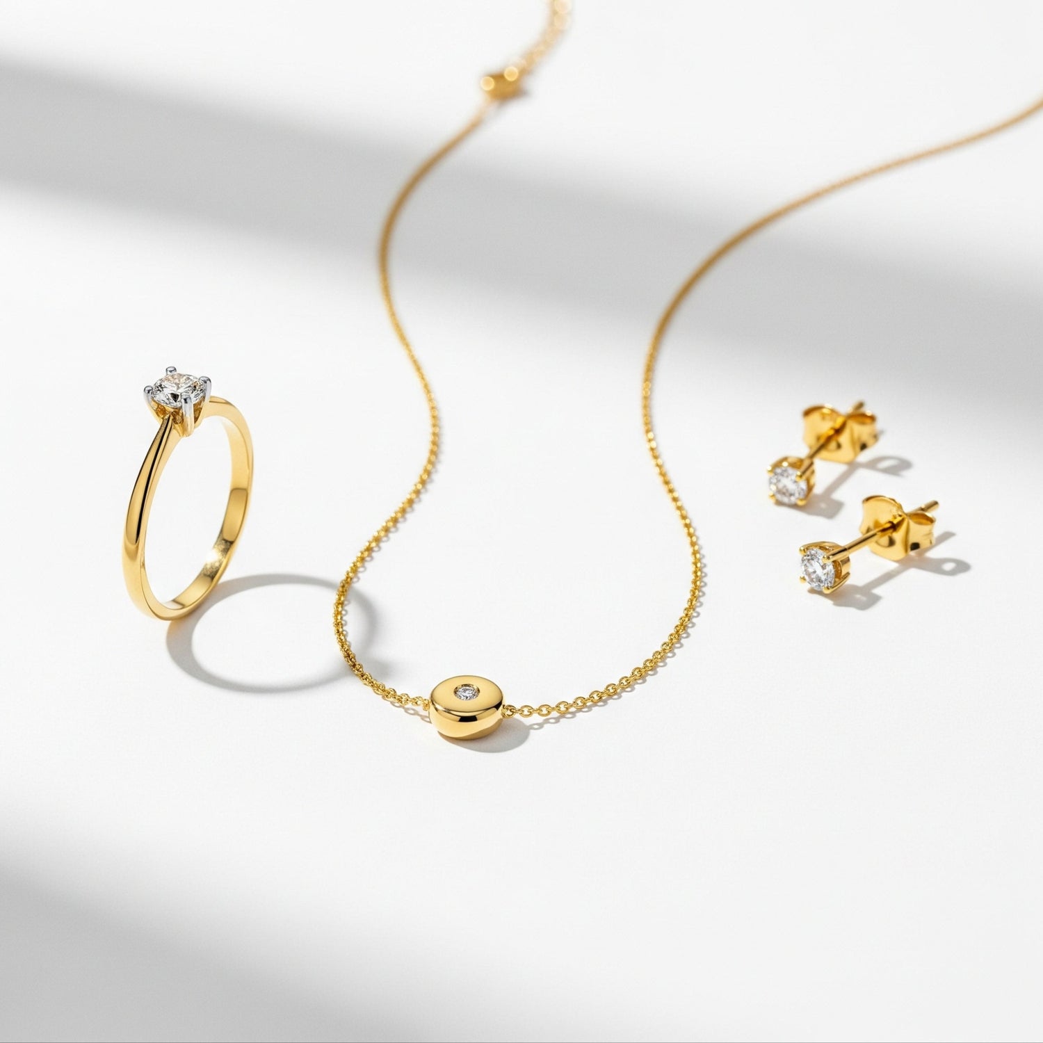 Gold jewelry set including a ring, bracelet, and earrings on a light background
