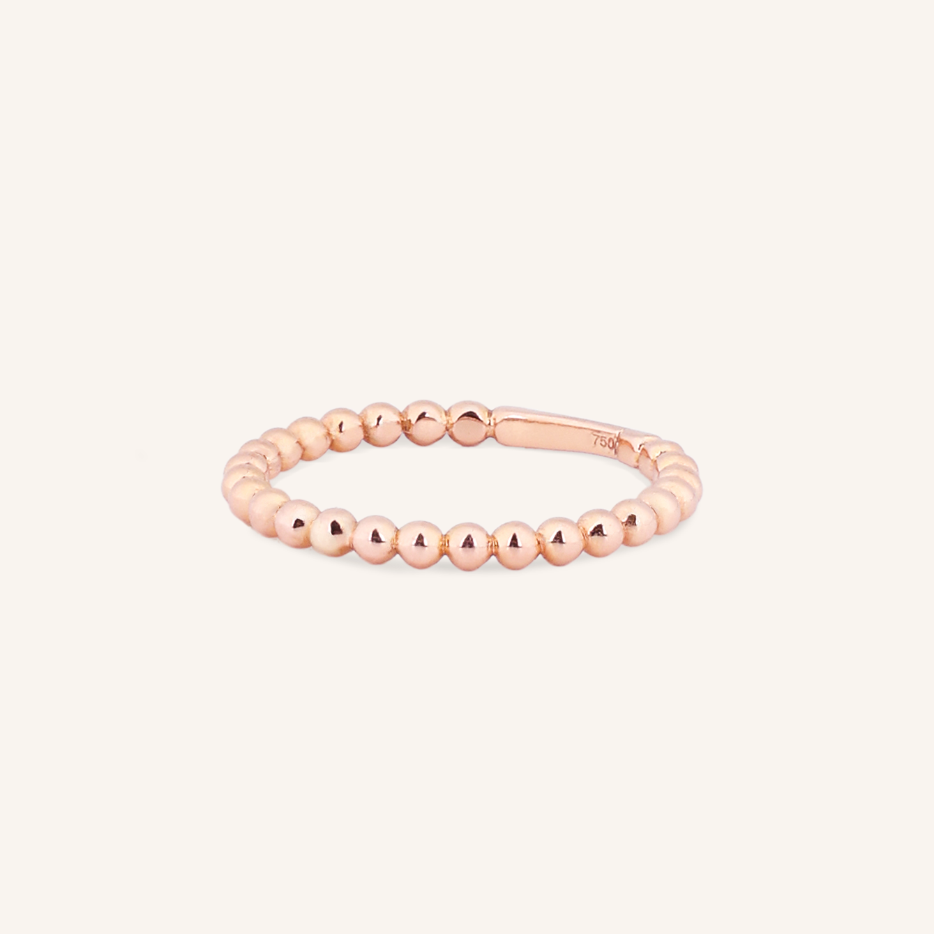 Rose gold beaded ring on a white background