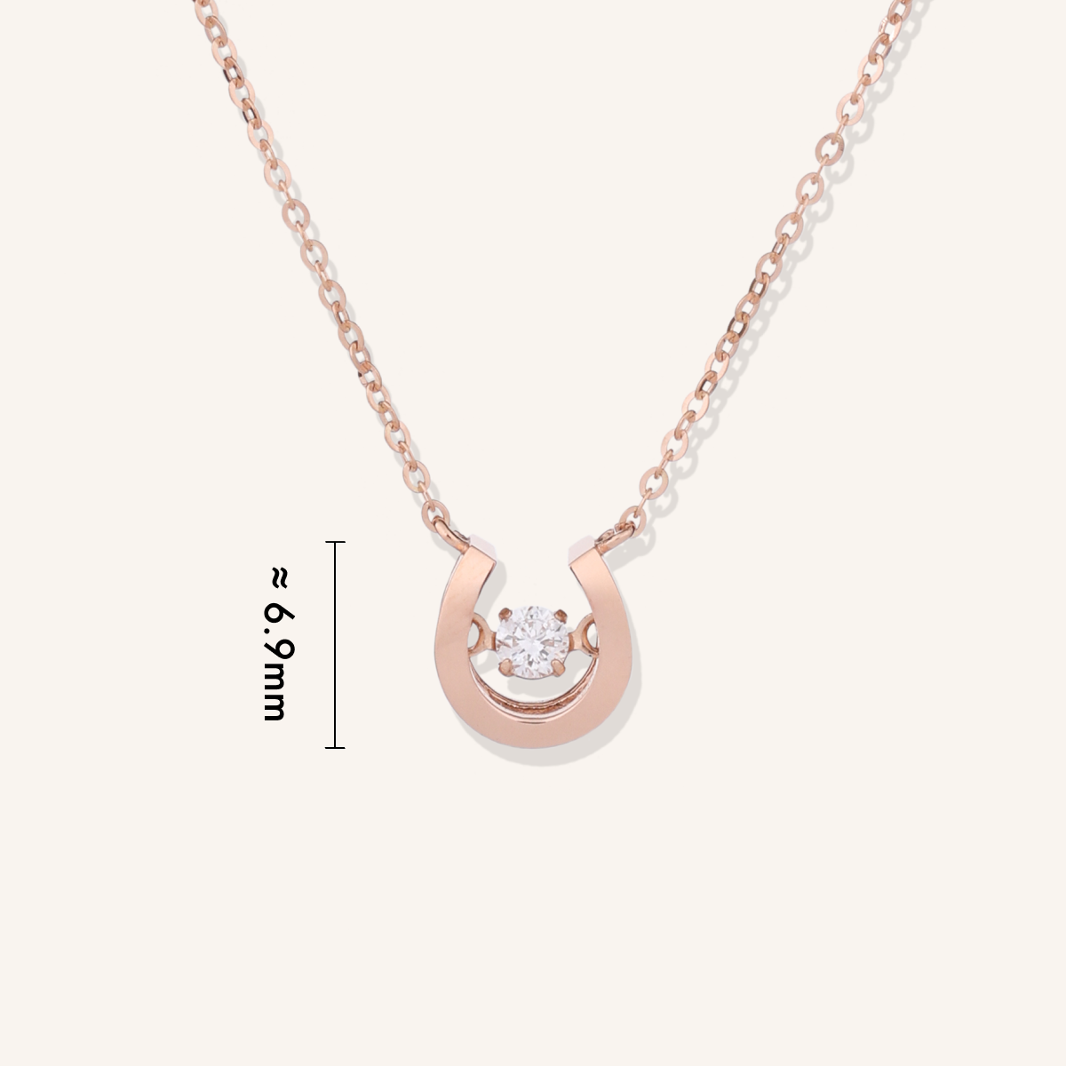 Rose gold horseshoe necklace with diamond on a white background