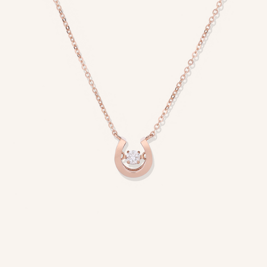 Rose gold necklace with a small diamond pendant on a white background