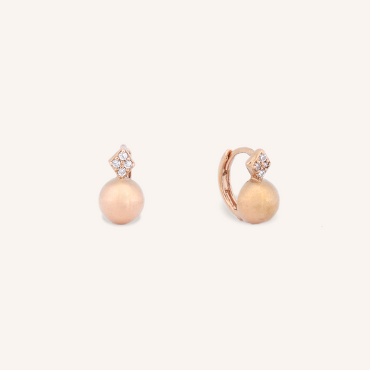 Pair of rose gold earrings with pearl-like beads on a white background
