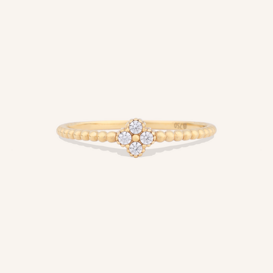 Gold ring with floral design on a white background