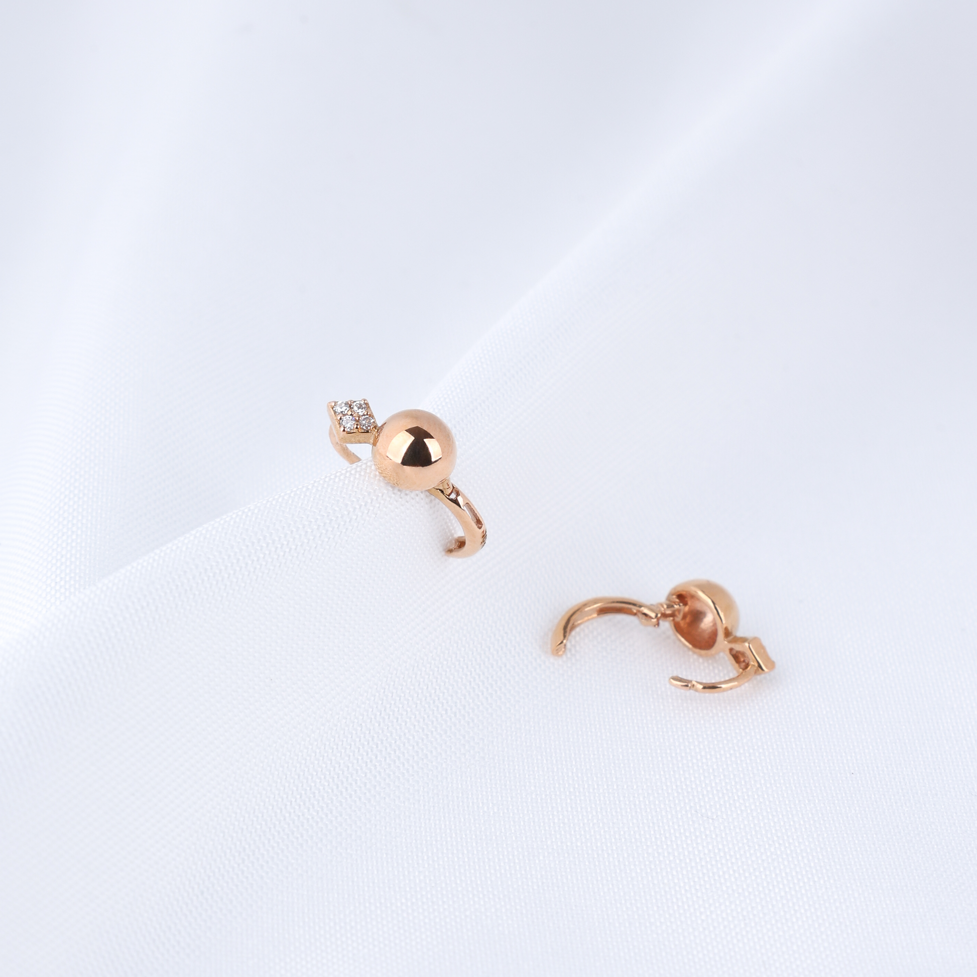 Rose gold earrings on a light gray background