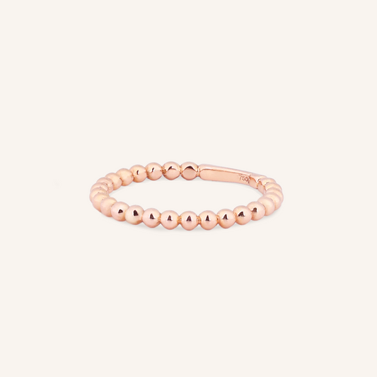 Rose gold beaded ring on a white background