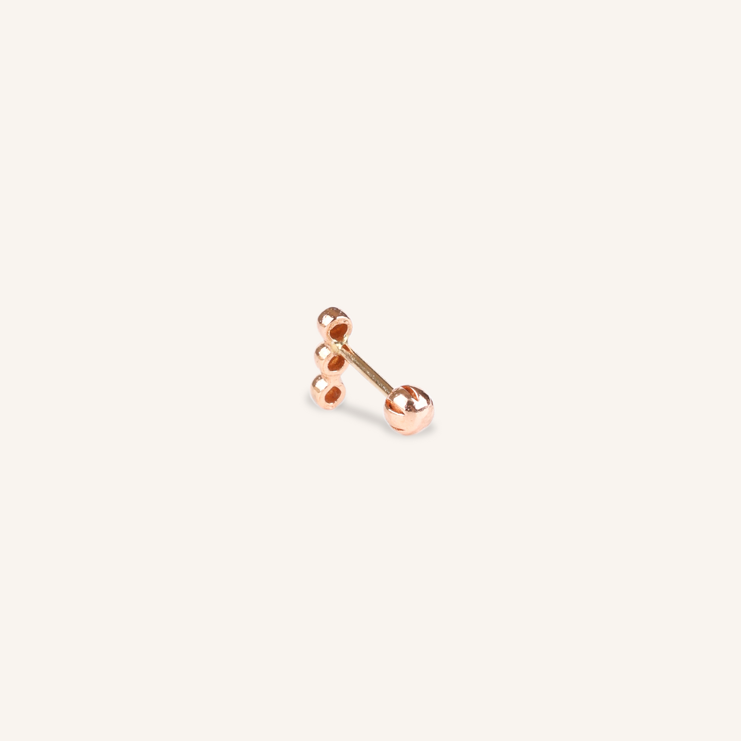 Close-up side view of a gold stud earring featuring three hollow circular ball accents stacked vertically, attached to a bar with a rounded screw-back closure