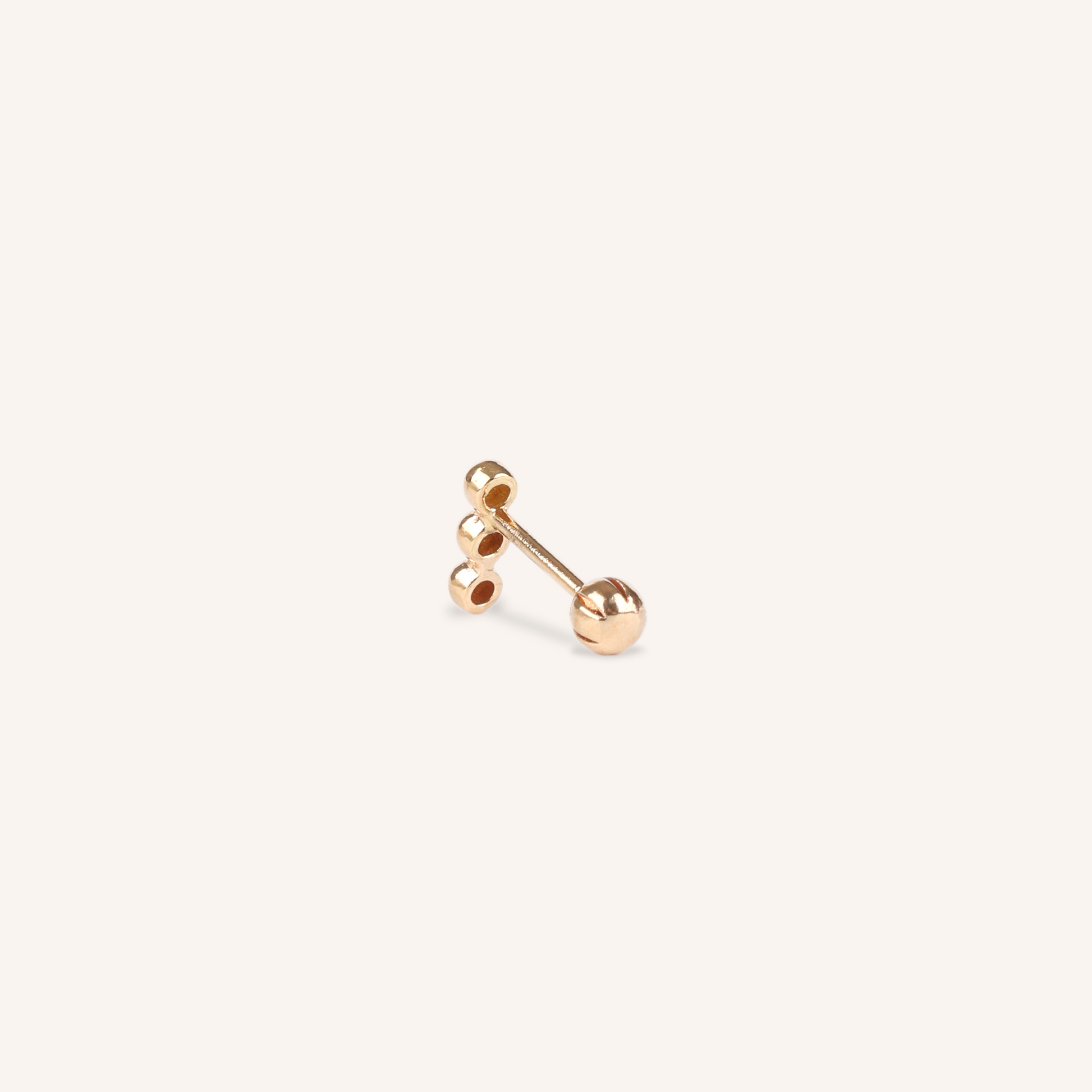 Close-up side view of a yellow gold stud earring featuring three hollow circular ball accents stacked vertically, attached to a bar with a rounded screw-back closure